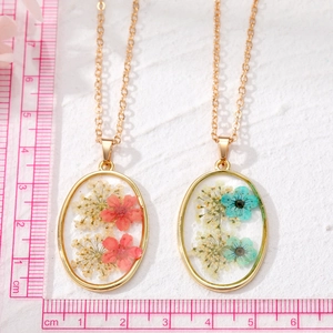 Oval pressed real flower pendant necklace in gold frame with transparent resin detail
