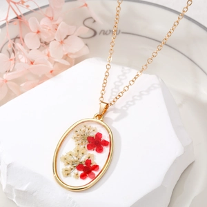 Oval gold necklace with real red and white dried flowers preserved in clear resin