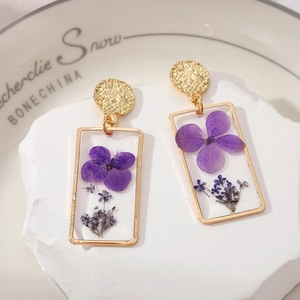 Square gold geometric earrings featuring real purple dried flowers in resin