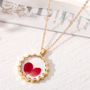 Vue latérale macro du collier en résine dorée avec de vrais pétales de fleurs rouges
