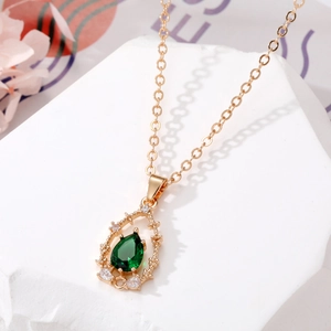 Collier en chaîne dorée avec pendentif goutte émeraude et design cristal évidé