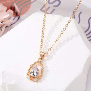 Vue détaillée du pendentif goutte ajouré avec zircon sur une chaîne dorée élégante