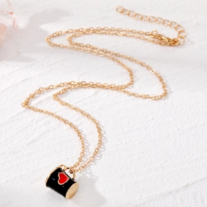 Collier en chaîne dorée avec un pendentif tasse en émail noir orné d'un cœur rouge