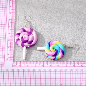 Detailed view of rainbow lollipop earrings showing 4.5cm length on a pink scale mat