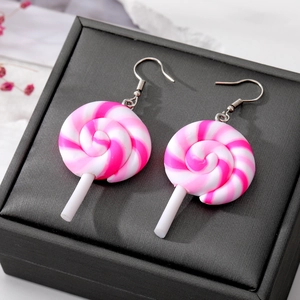 Macro shot of pink and white spiral lollipop earrings on a black textured jewelry box