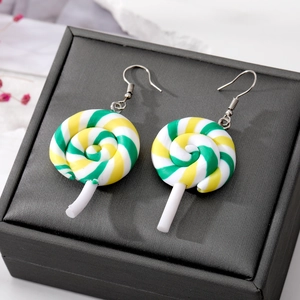 Detailed macro shot of green and yellow swirl lollipop earrings on black jewelry box