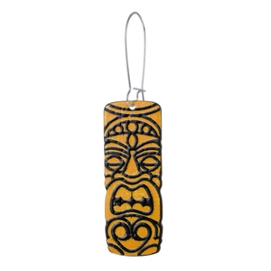 Detailed macro view of long orange tiki face earrings with black tribal carvings