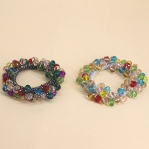 Deux élastiques à cheveux stylés avec perles de verre colorées et facettées, vue à plat