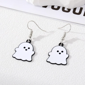 Close-up of cute ghost earrings in black and white enamel on a minimalist white backdrop