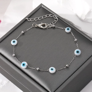 Macro shot of silver chain bracelet with evil eye beads and adjustable lobster clasp