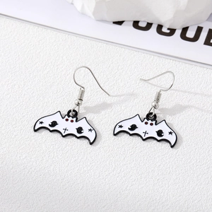 Macro detail of white enamel bat earrings with gothic ghosts and red eyes on metal
