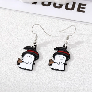 Close-up of cute Halloween ghost earrings with witch hat and broom in enamel finish