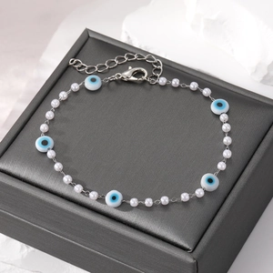 Chic pearl bracelet featuring blue evil eye charms and a silver adjustable metal chain