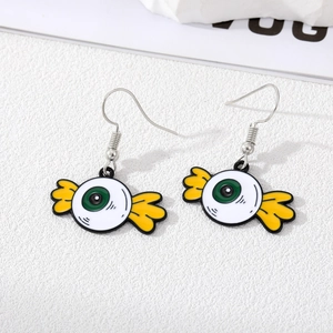 Detail view of handmade enamel Halloween eyeball earrings with yellow wings on white surface