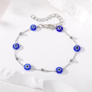Silver chain bracelet featuring blue evil eye charms and round metallic beads for women