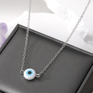 Minimalistische zilveren ketting met kleurrijke Evil Eye hanger op zwarte juwelendoos
