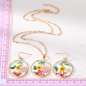 Conjunto de joyas de flores hechas a mano en oro con flores secas en resina y aretes