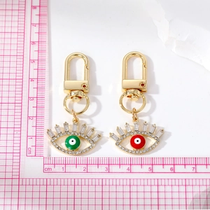 Detail view of gold alloy devil eye keychains with colorful enamel and sparkling rhinestones
