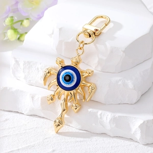 Porte-clés Evil Eye doré avec incrustation de cristal bleu sur un socle en pierre
