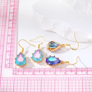Gros plan de boucles d'oreilles en cristal goutte d'eau avec dégradé et règle de mesure