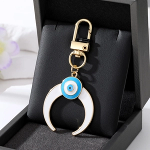 Porte-clés lune dorée avec breloque en émail œil bleu dans un coffret cadeau élégant
