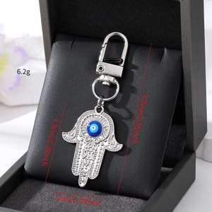 Silberner Hamsa-Hand-Schlüsselanhänger mit blauer Evil Eye Perle und genauen Maßen