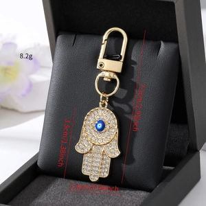 Detailansicht der Hamsa-Hand-Schlüsselanhänger mit Kristallen und blauem Auge