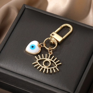 Porte-clés œil maléfique doré avec cœur blanc et pendentif géométrique à cils creux