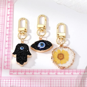 Resin Evil Eye keychain set with dried flowers and Fatima hand charms in gold finish