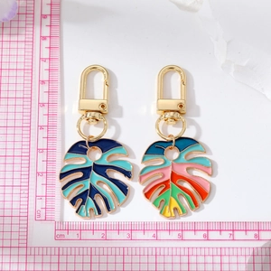 Détail des porte-clés feuille de monstera colorés en émail avec crochets en métal doré