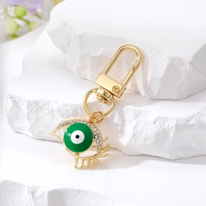 Ethnic gold evil eye keychain with green oil drip center and sparkling white rhinestones