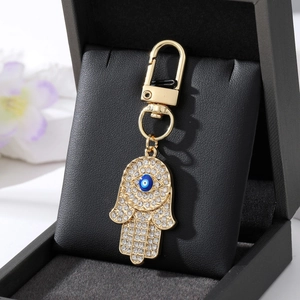 Goldener Hamsa-Hand Schlüsselanhänger mit blauem Auge und funkelnden Strasssteinen