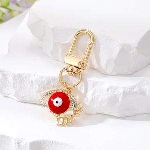 Ethnic Evil Eye keychain with golden alloy and sparkling rhinestones on white stone