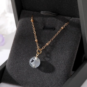 Golden necklace with Turkish Evil Eye bead pendant displayed in velvet jewelry box