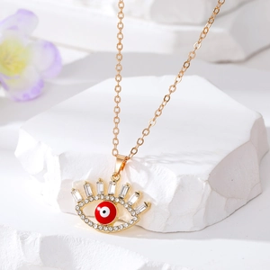 Détail du collier œil protecteur doré avec centre rouge et cils en zircons brillants