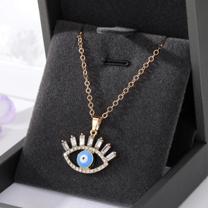 Collier vintage avec pendentif œil maléfique plaqué or et zircons dans une boîte à bijoux
