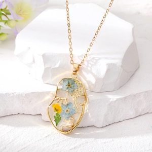 Collier visage abstrait avec fleurs séchées dans résine et chaîne dorée
