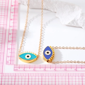 Vue détaillée du pendentif œil maléfique en émail bleu à côté d'une règle de mesure