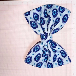 Détail du nœud papillon imprimé œil maléfique bleu montrant la texture et les dimensions