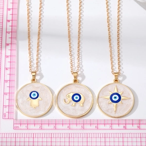Detailed view of Evil Eye Hamsa and Elephant pendants with measurement scale