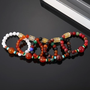 Retro handmade beaded bracelet with agate, obsidian and engraved mantra beads on black surface
