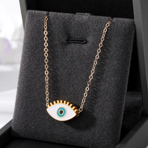 Collier oeil maléfique avec cils dorés et pendentif émail bleu sur présentoir