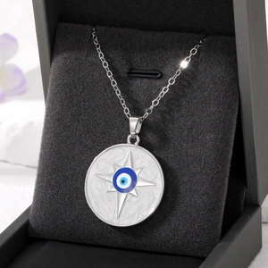Detail of evil eye necklace with star motif on a black velvet jewelry box display