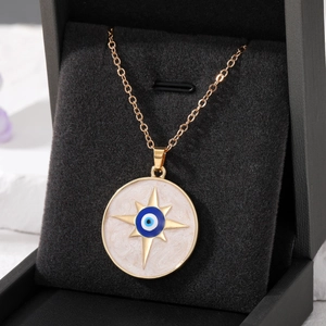 Detail of golden Evil Eye necklace with white shell inlay inside a premium jewelry box