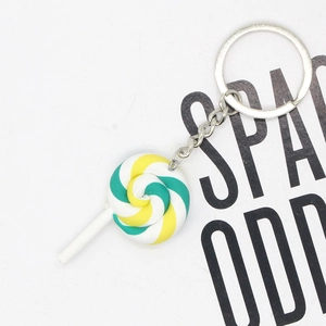Close-up of green and yellow spiral resin lollipop keychain with silver metal ring