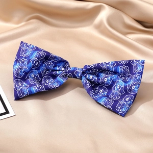 Pince à cheveux nœud en satin bleu marine avec motif main de Hamsa sur tissu champagne