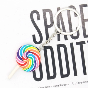 Detailed view of a colorful rainbow spiral lollipop keychain with silver metal ring chain