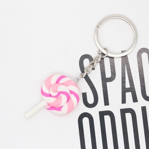 Detailed macro view of a pink and white spiral resin lollipop pendant with silver keychain