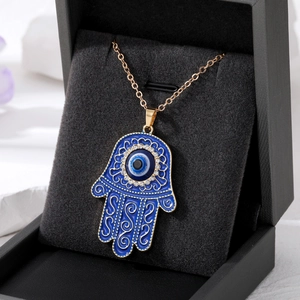 Collier Main de Fatima et Œil Bleu en émail bleu avec accents dorés sur boîte à bijoux