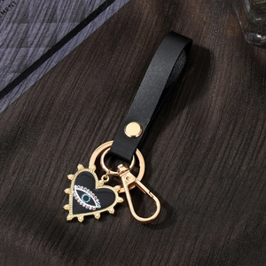 Detail of evil eye heart pendant with pearls and black leather strap keychain